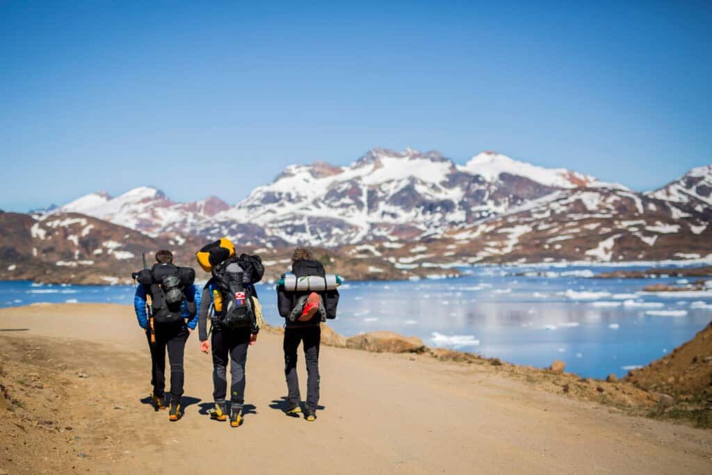 Hikers heading out of Tasiilaq along the fjord
